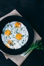 Fried eggs in cast iron frying pan on dark wooden background Royalty Free Stock Photo