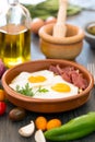 Fried eggs in a ceramic cup with spanish jamon for breakfast on black background Royalty Free Stock Photo