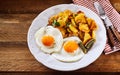 Fried eggs with crispy roast potatoes and gherkin