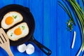 fried eggs, crispy toast and spring onion on blue wooden table