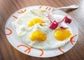 Fried eggs with fresh red radish on the plate at the table Royalty Free Stock Photo