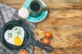 Fried eggs in frying pan, toast heart shape, cup of coffee