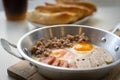 Fried eggs in a pan with meat on the wooden plate. The famous breakfast with Banh Mi - Vietnamese bun with meat Royalty Free Stock Photo