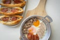 Fried eggs in a pan with meat on the wooden plate. The famous breakfast with Banh Mi - Vietnamese bun with meat. Top-view Royalty Free Stock Photo