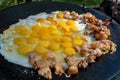 Fried eggs with pieces of pork on a large flat pan, cooking outdoors Royalty Free Stock Photo