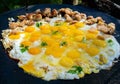 Fried eggs with pieces of pork on a large flat pan, cooking outdoors Royalty Free Stock Photo