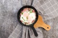 Fried eggs with sausage in a cast-iron frying pan on a dark background Royalty Free Stock Photo