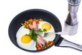 Fried eggs with sausage and vegetables in frying pan on white ba Royalty Free Stock Photo