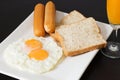 Fried eggs with sausages and bread on the white plate Royalty Free Stock Photo