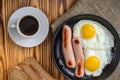 fried eggs with sausages and coffee. traditional modest breakfast Royalty Free Stock Photo