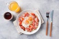 Fried eggs sausages and tomatoes on a plate on the table. Rich homemade Breakfast. Gray concrete background. Copy space Royalty Free Stock Photo