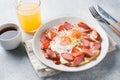 Fried eggs sausages and tomatoes on a plate on the table. Rich homemade Breakfast. Gray concrete background. Copy space Royalty Free Stock Photo
