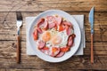 Fried eggs sausages and tomatoes on a plate on the table. Rich homemade Breakfast. Wooden background. Copy space Royalty Free Stock Photo