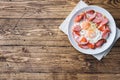 Fried eggs sausages and tomatoes on a plate on the table. Rich homemade Breakfast. Wooden background. Copy space Royalty Free Stock Photo
