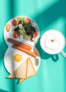 Fried eggs with sausages, tomatoes and toasts on white background on colorful green abstract background. Royalty Free Stock Photo