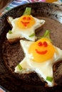 Fried eggs shaped as stars with funny faces Royalty Free Stock Photo