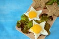 Fried eggs and slices of brown bread shaped as stars