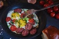 Fried eggs with smoked sausage in a frying pan. Royalty Free Stock Photo