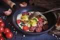 Fried eggs with smoked sausage in a frying pan. Royalty Free Stock Photo