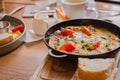 Fried eggs with tomato and ham in pan. Served breakfast table. Omelette with tomato and bread. Spanish tortilla. Royalty Free Stock Photo