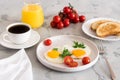 Fried eggs with tomatoes and herbs, toast, coffee and juice