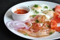 Fried eggs with tomatoes, red onion, bacon for breakfast on a white plate Royalty Free Stock Photo