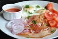 Fried eggs with tomatoes, red onion, bacon for breakfast on a white plate Royalty Free Stock Photo