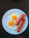 Fried eggs from two eggs and two sausages on a white plate Royalty Free Stock Photo