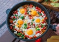 Fried eggs with vegetables and baguette spread with garlic sauce. Morning breakfast