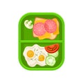 Fried eggs with vegetables and sandwich with cheese and salami on green plastic tray. Tasty food for breakfast. Flat