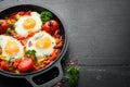 Fried eggs with vegetables: tomatoes, paprika, peppers, onions. Vegetable Shakshuka in a pan. Top view. Royalty Free Stock Photo