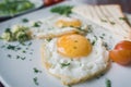 Fried eggs on white plate with green and tomato cherry - breakfast, macro view Royalty Free Stock Photo