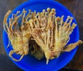 Fried enoki mushroom on a blue bowl