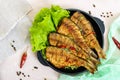 Fried fish carp sazan on a cast-iron frying pan with lettuce leaves