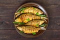 Fried fish carp sazan on a ceramic bowl with branches of rosemary