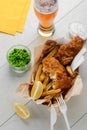 Fried fish and chips. Meal with green peas, salad, lemons and beer Royalty Free Stock Photo