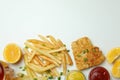 Fried fish and chips, sauces, lemon and beer on white background