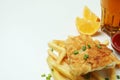 Fried fish and chips, sauces, lemon and beer on white background