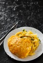 Fried fish fillet in cheese and potatoes in a white plate on black background. Royalty Free Stock Photo