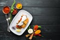 Fried fish fillet with vegetables in creamy sauce. In the plate. On a wooden background. Top view Royalty Free Stock Photo