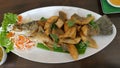 Fried fish fillets Arrange the dish with the head and fishbone. Placemat with banana leaves on a white plate. Thai food