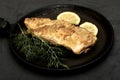 fried fish with lemon and herbs in a frying pan on the table Royalty Free Stock Photo