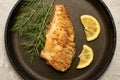 fried fish with lemon and herbs in a frying pan on the table Royalty Free Stock Photo