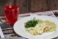 Fried fish and mashed potato with glass of fruit-drink on wooden table