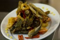 Fried fish in oil with calamar rings and pimiento peppers