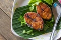 Fried Fish with Spicy Salad Dressing on wood table close up