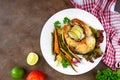 Fried fish steak with grilled vegetables on a white plate. Proper nutrition. Royalty Free Stock Photo