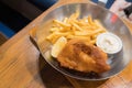 Fried fish steak served with french fries and tartar sauce in a deep pan placed Royalty Free Stock Photo