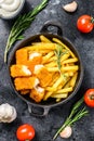 Fried Fish Sticks with French Fries. Fish Fingers. British fish and chips, fried potato. Black background. Top view Royalty Free Stock Photo
