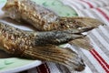 fried fish tails on a plate on a woven towel